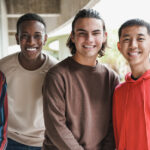 group of happy multiethnic boys smiling on camera at school outd