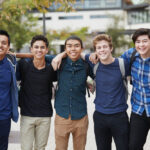 portrait of male high school students outside college buildings