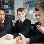 schoolboys discussing ideas in class
